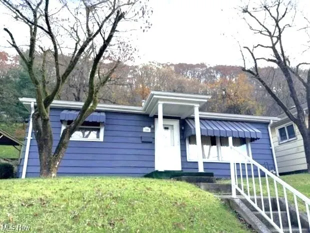 View of front of home with a front yard and covered porch