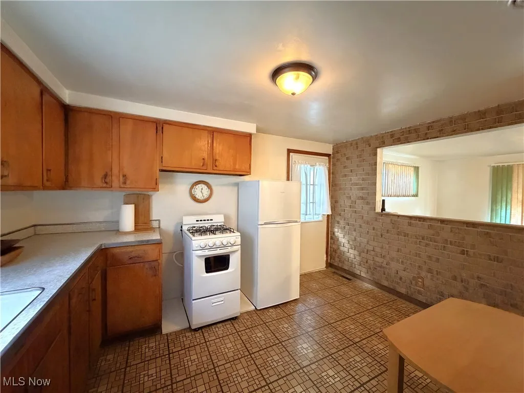 Kitchen with white appliances, and brown cabinetry