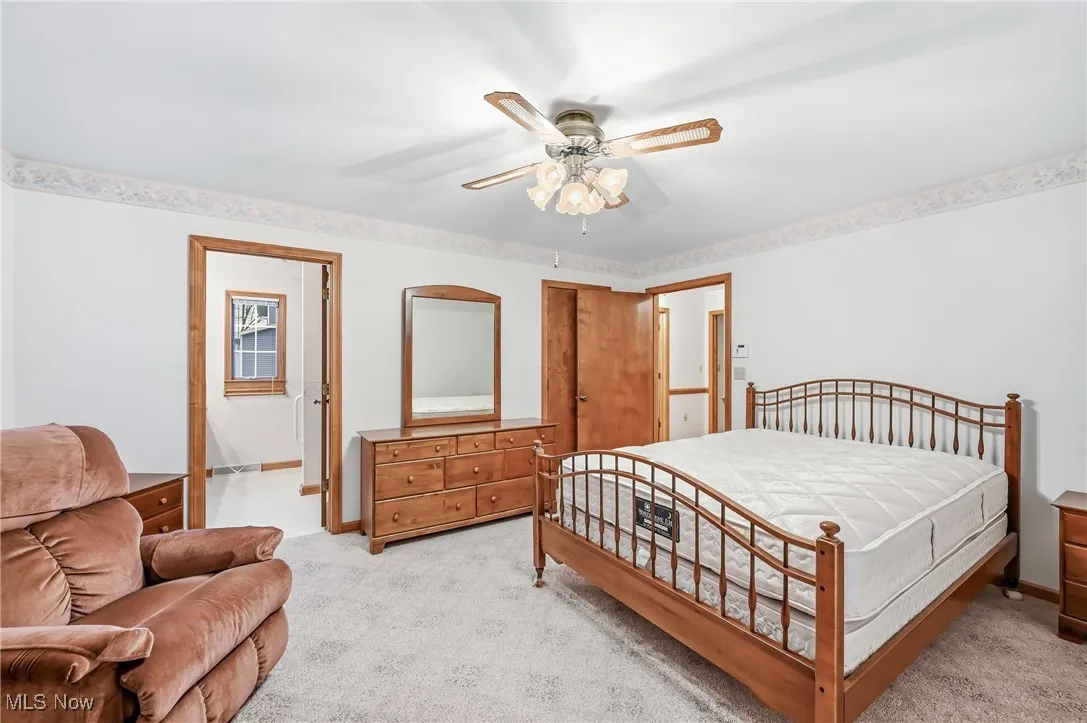 Carpeted bedroom featuring ceiling fan and baseboards