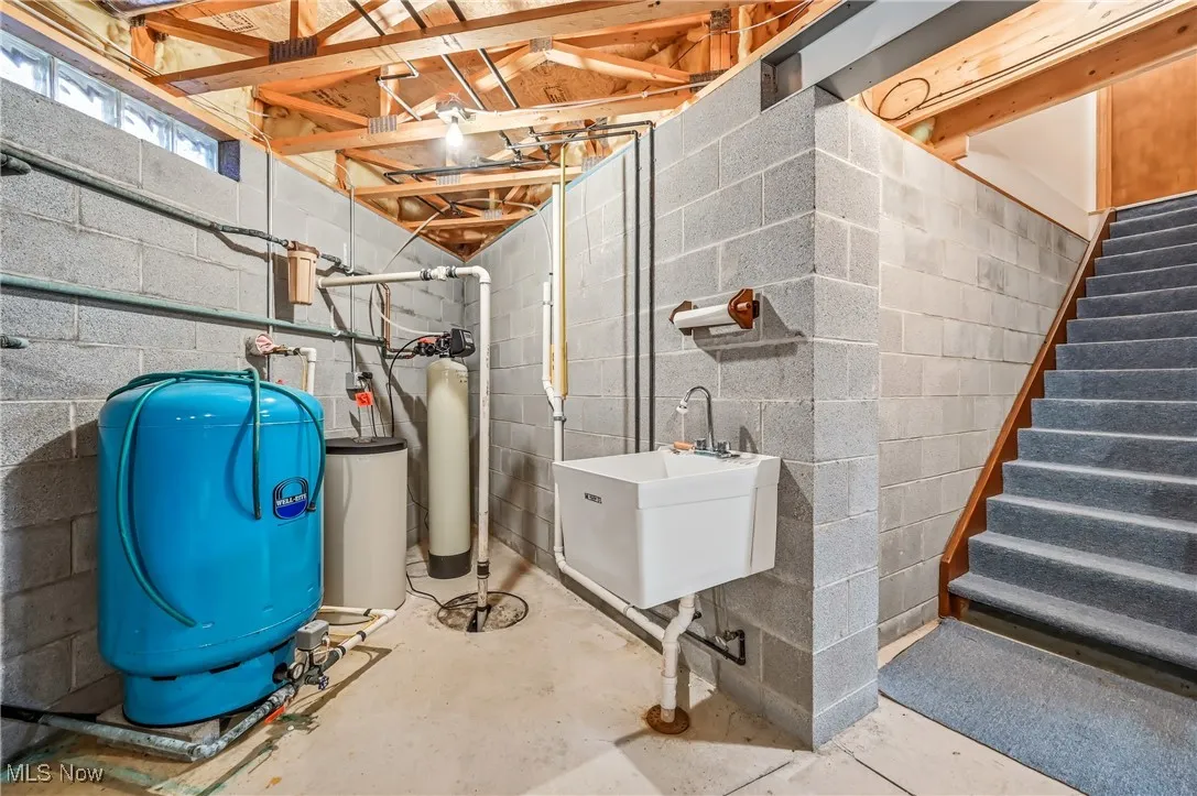 Below grade area featuring a water pressure tank and a water softener