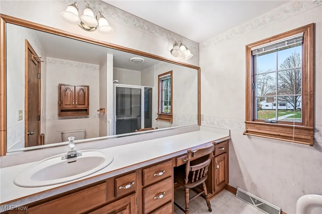 Bathroom featuring a stall shower, healthy amount of natural light, and vanity