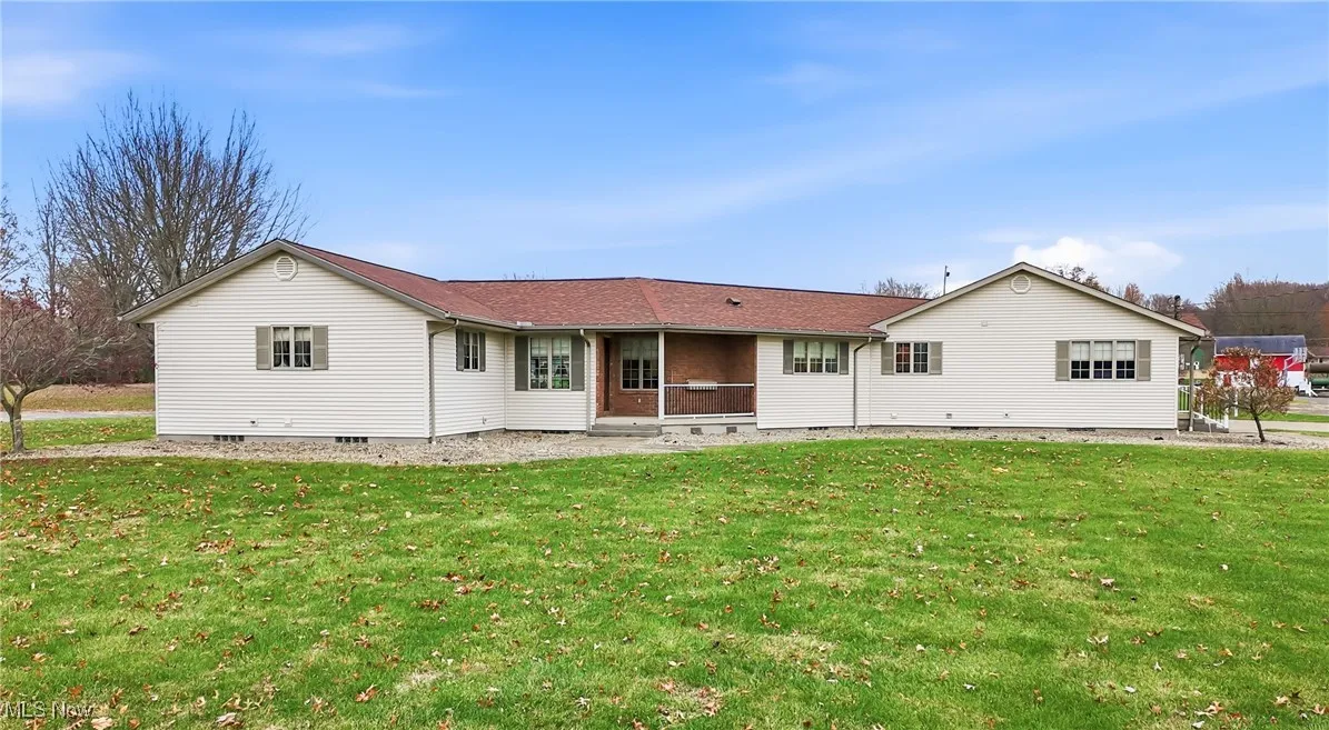 Rear view of house featuring a lawn, crawl space, and a patio