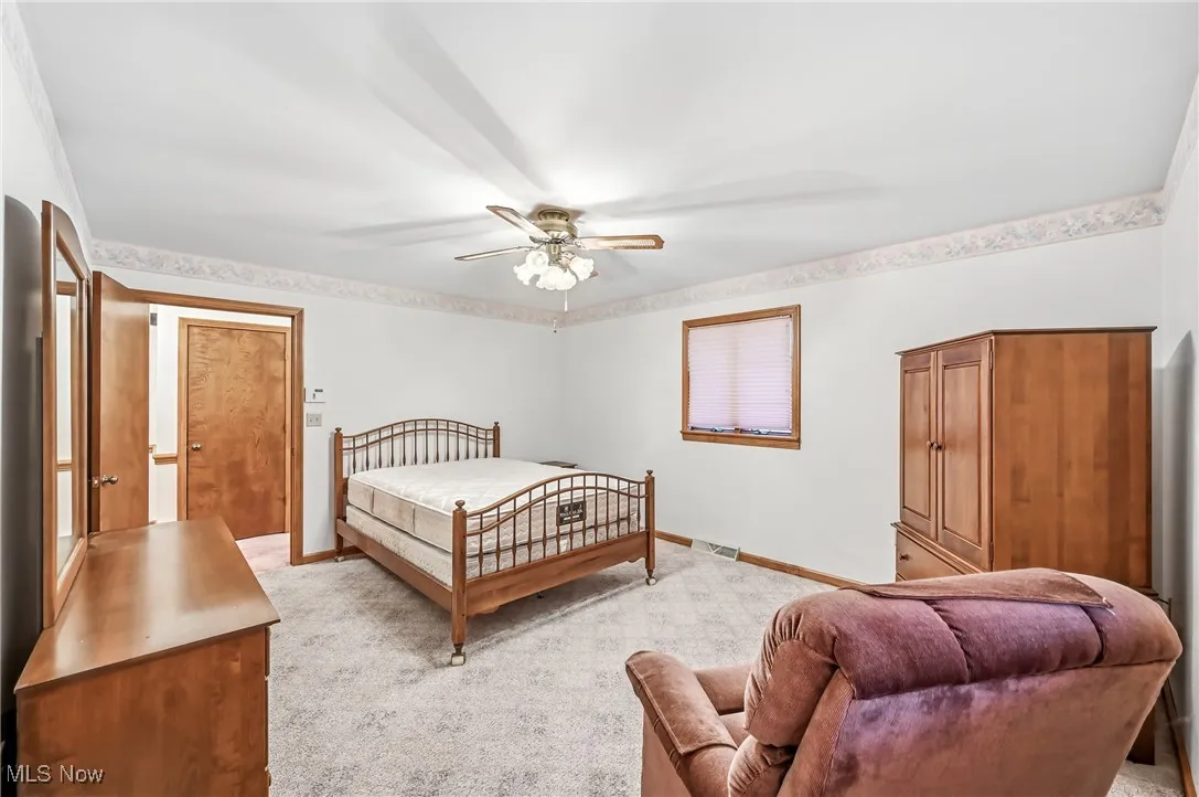 Bedroom with light carpet and a ceiling fan