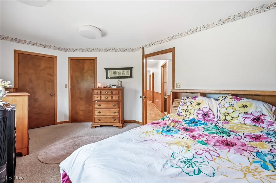 Bedroom with light carpet and two closets