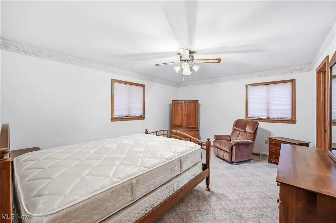 Bedroom featuring light carpet and a ceiling fan