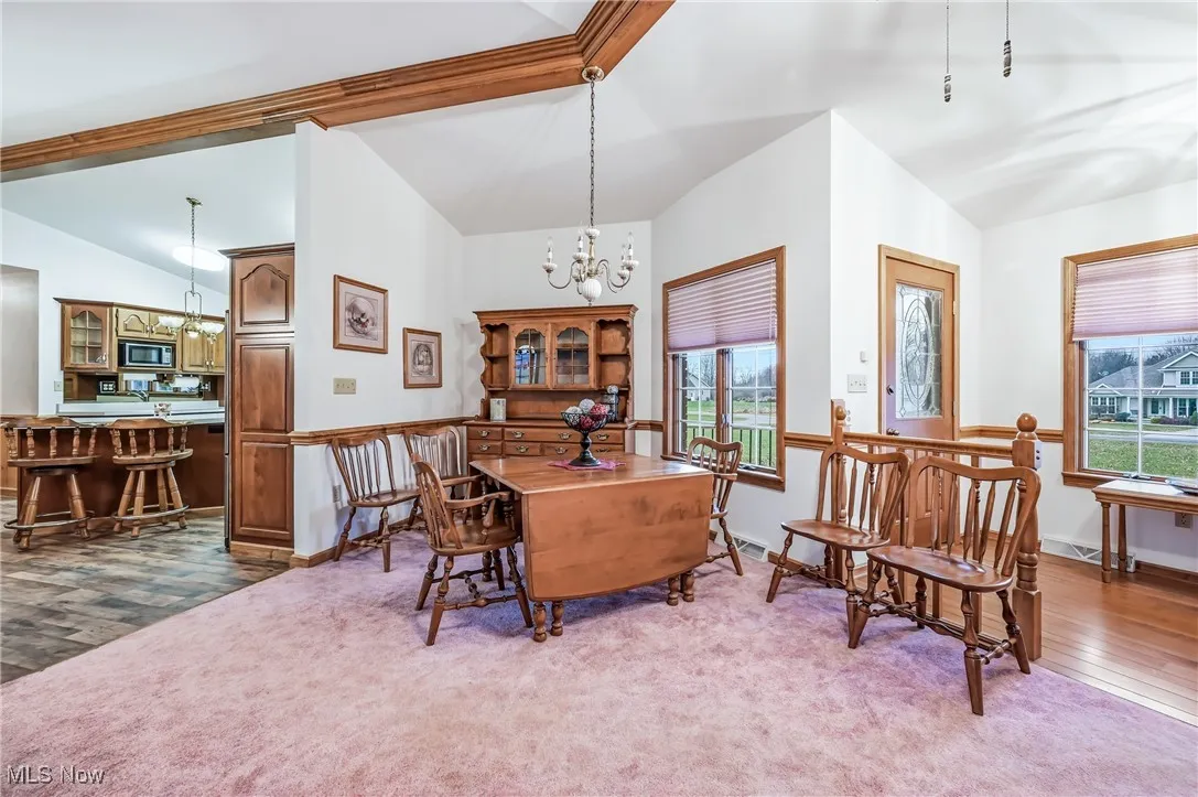 Dining room featuring a chandelier, dark wood-type flooring, and dark carpet