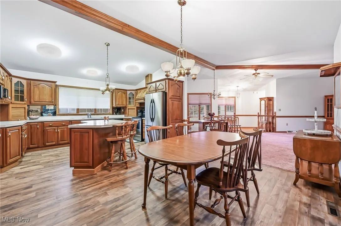 Dining area with a chandelier, light wood-type flooring, and a ceiling fan