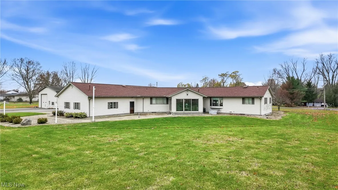 Back of house with a patio and a lawn