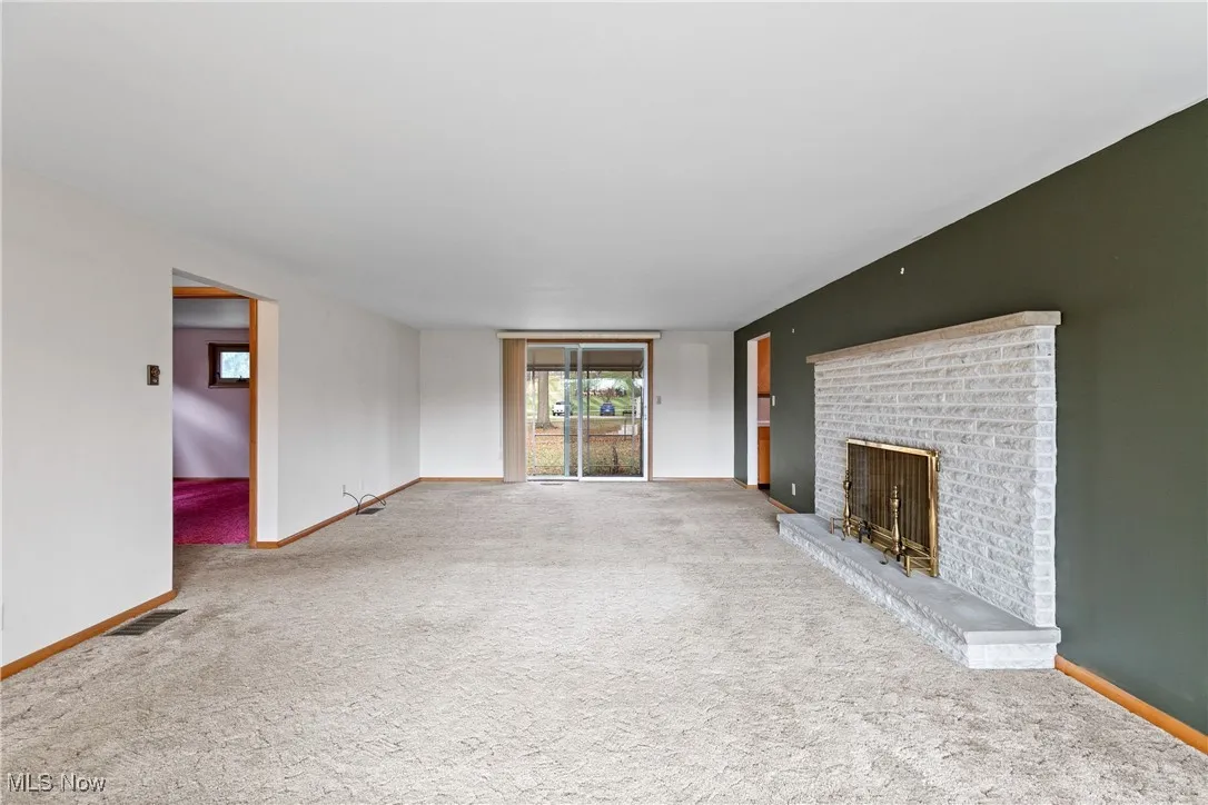 Spacious living room with fireplace w/electric logs and sliding door to the back.