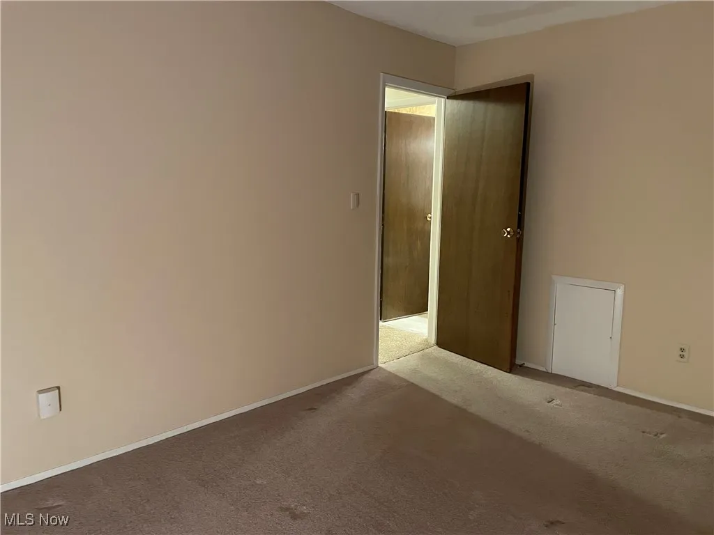 Carpeted empty room featuring baseboards
