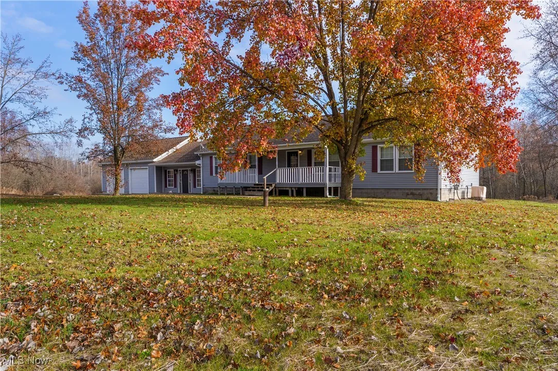 View of front of house with a front lawn, a garage, and covered porch