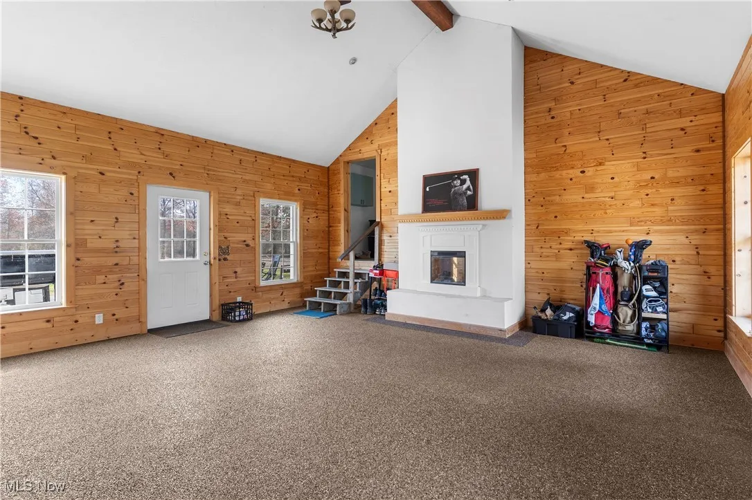 Rec room with nature stone flooring.  This sits between the garage and the access into the house which is the laundry room. Electric fireplace
