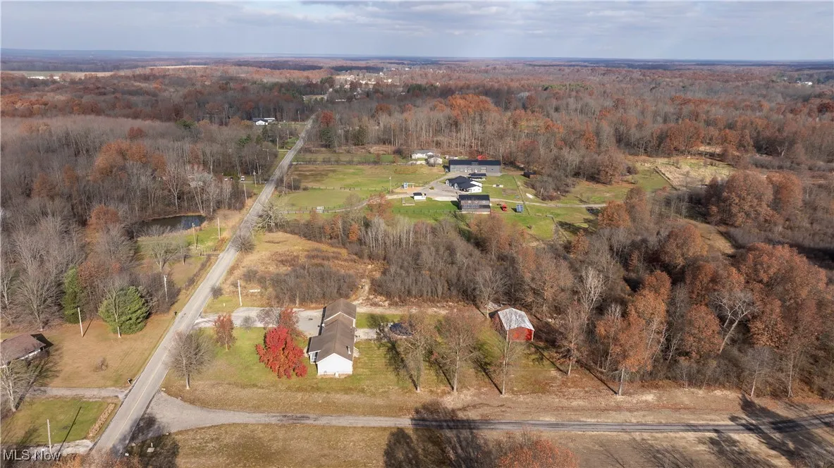 Aerial view of property's location with a heavily wooded area