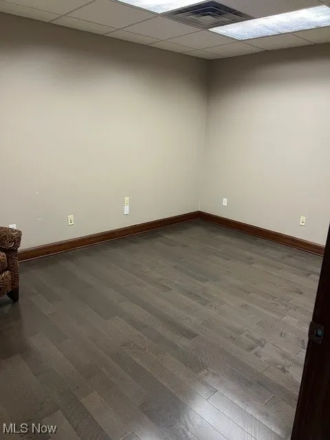 Empty room featuring wood finished floors and a paneled ceiling