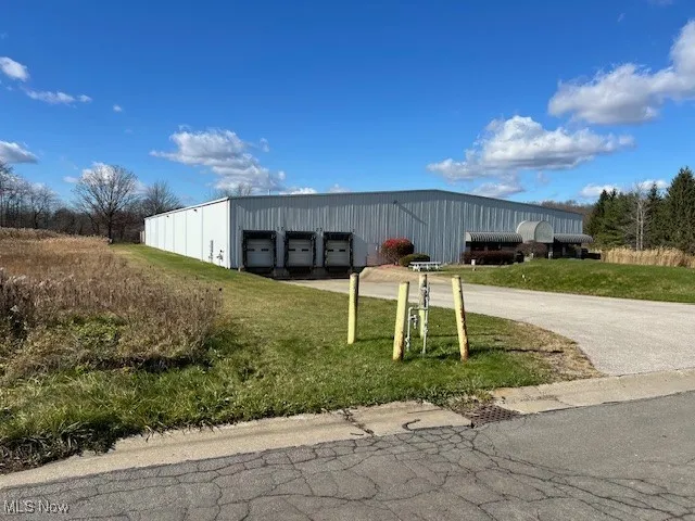 View of building exterior with a garage and driveway