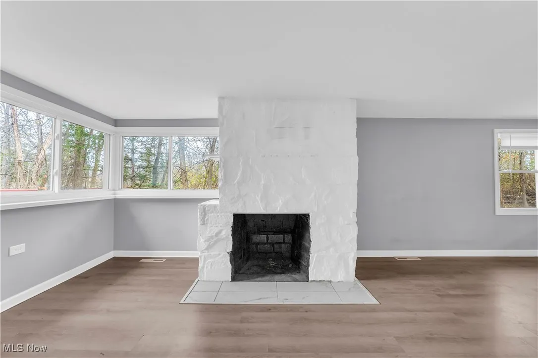 Detailed view of a large fireplace and wood finished floors