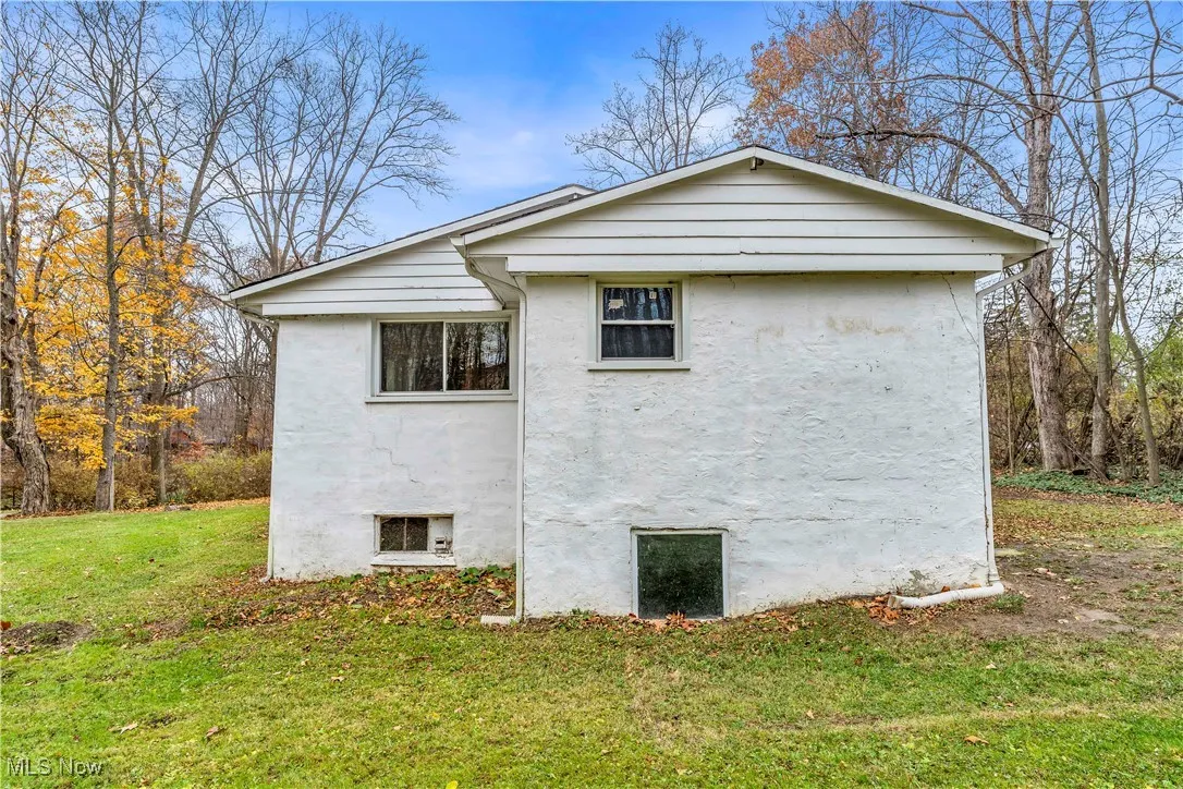 View of side of property featuring stucco siding and a lawn