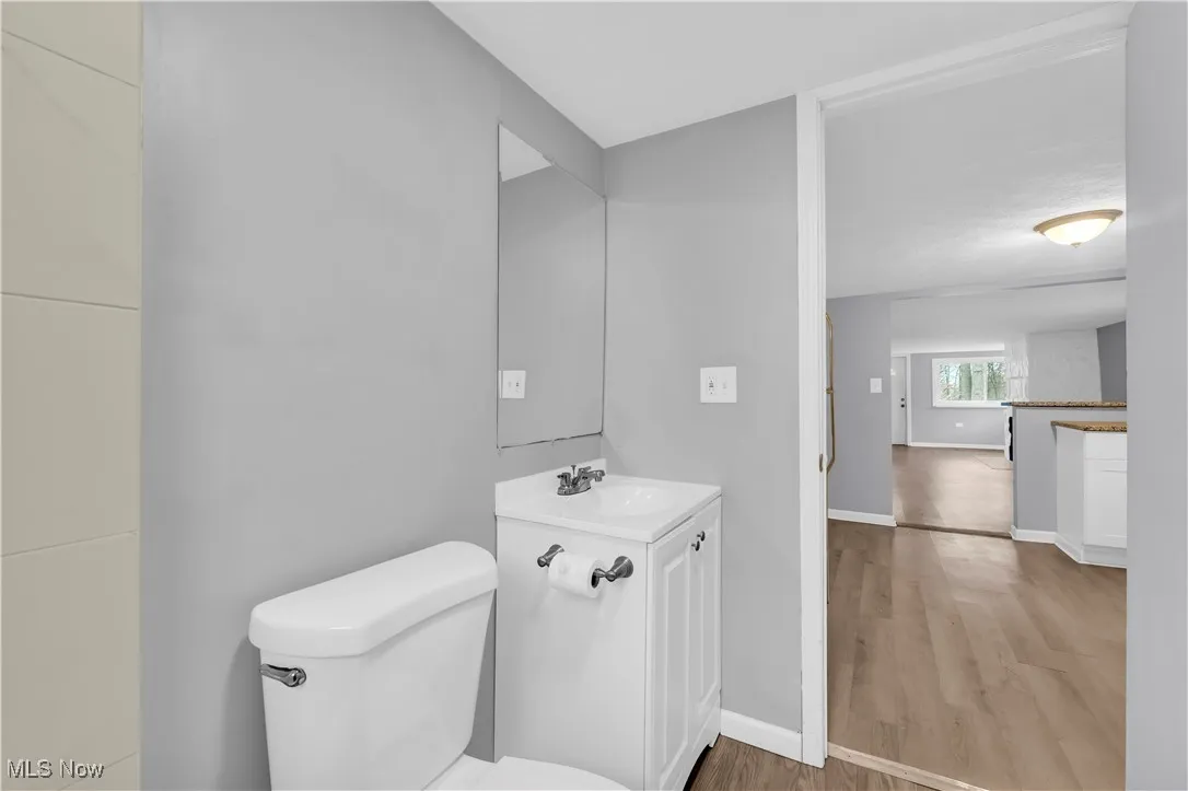 Half bath with light wood-style flooring and vanity