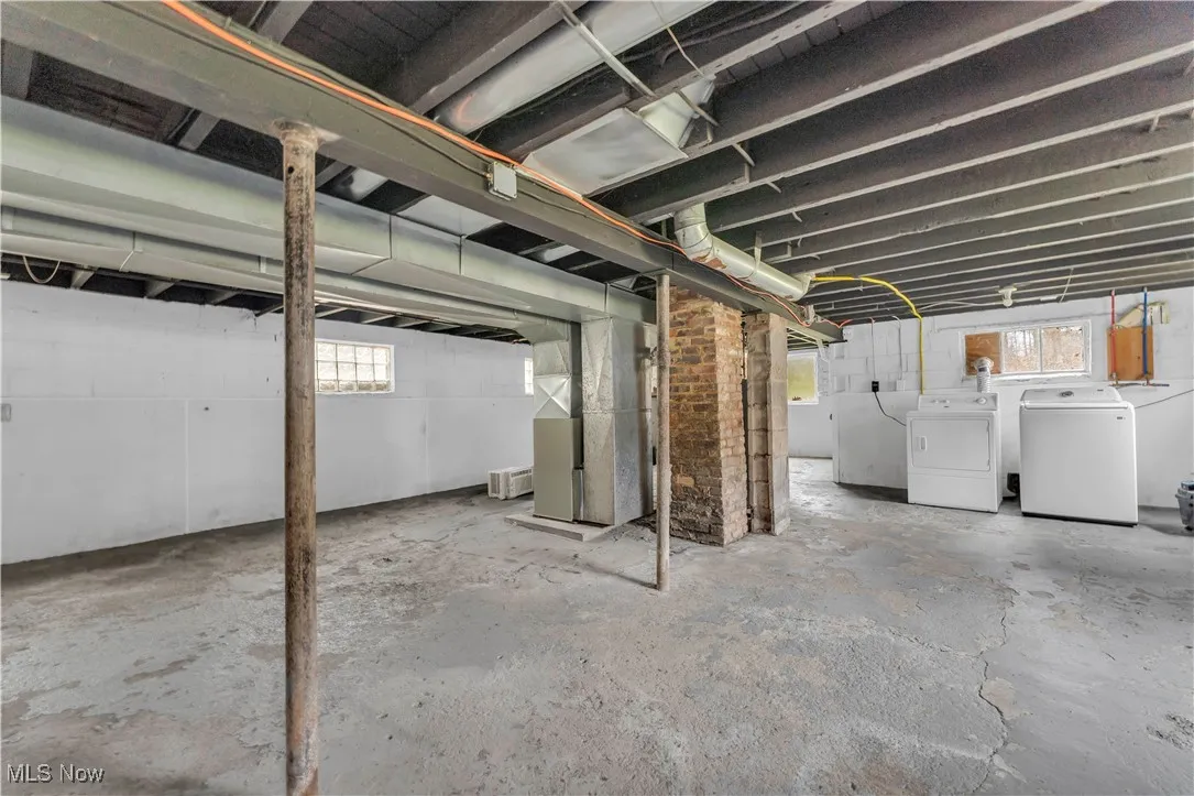 Below grade area featuring healthy amount of natural light, independent washer and dryer, and heating unit