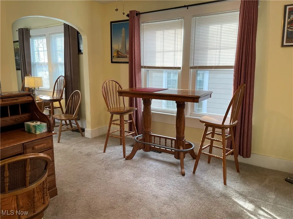 Dining area with light carpet and arched walkways
