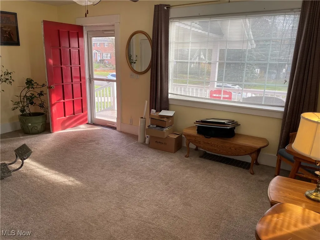Foyer entrance featuring light colored carpet and baseboards