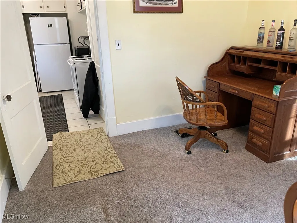 Office space featuring light colored carpet and baseboards