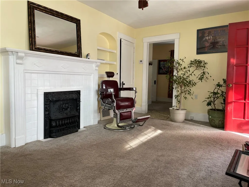 Sitting room featuring carpet flooring, a tile fireplace, and built in features
