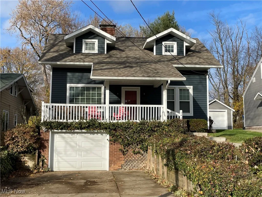 Bungalow-style house featuring roof with shingles, a garage, a porch, a chimney, and concrete driveway