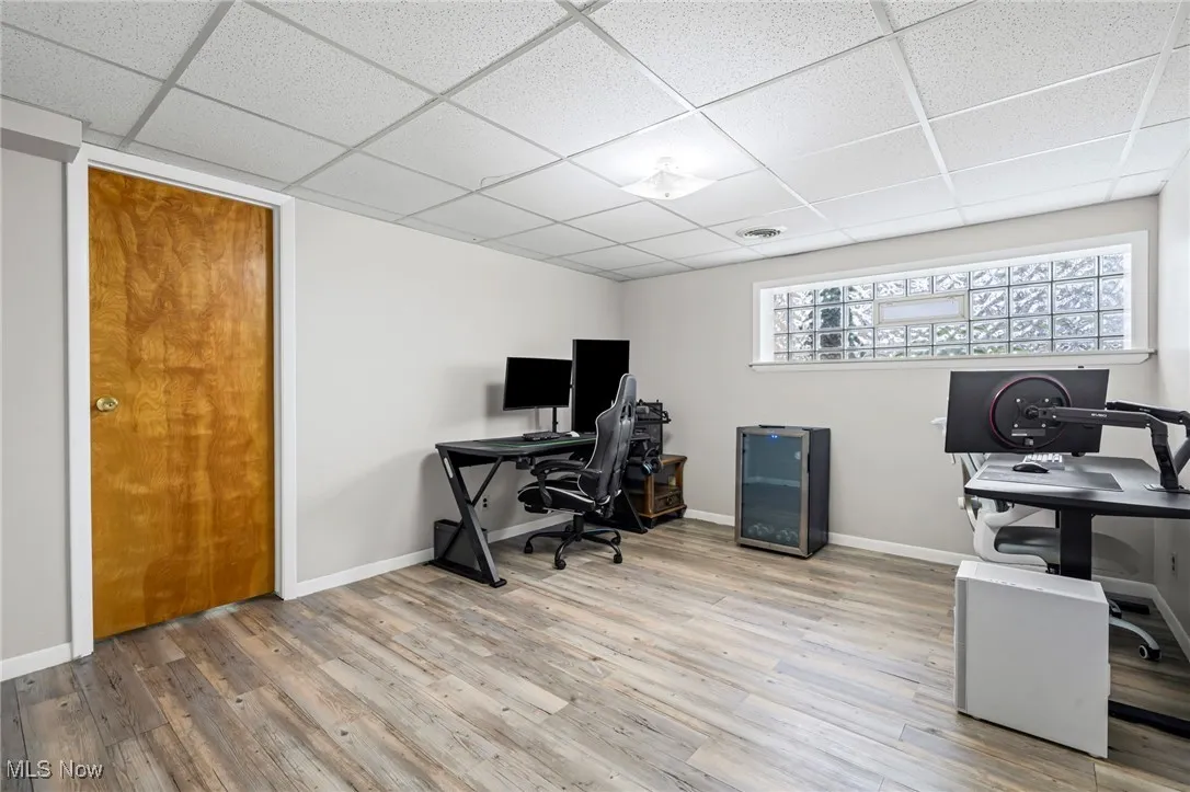 Office area with a paneled ceiling and wood finished floors