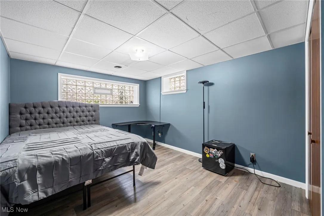Bedroom featuring a drop ceiling and wood finished floors