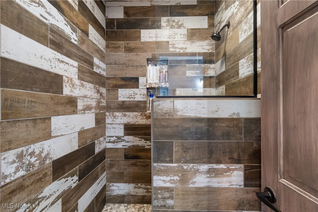 Full bath featuring tiled shower