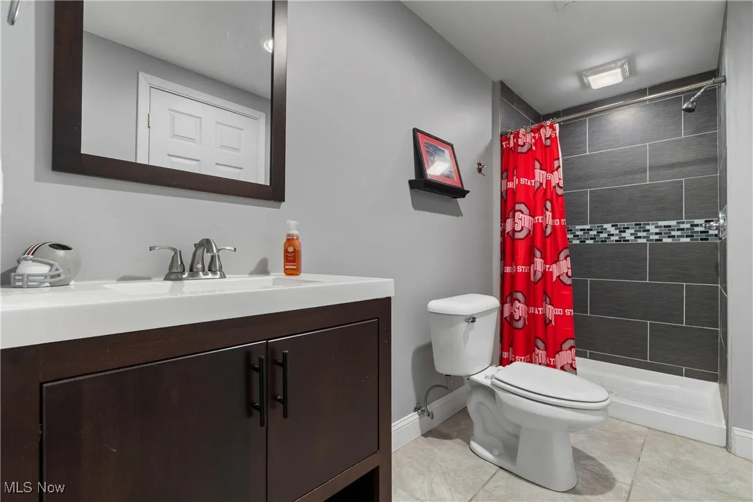 Full bath featuring vanity, a stall shower, and light tile patterned floors