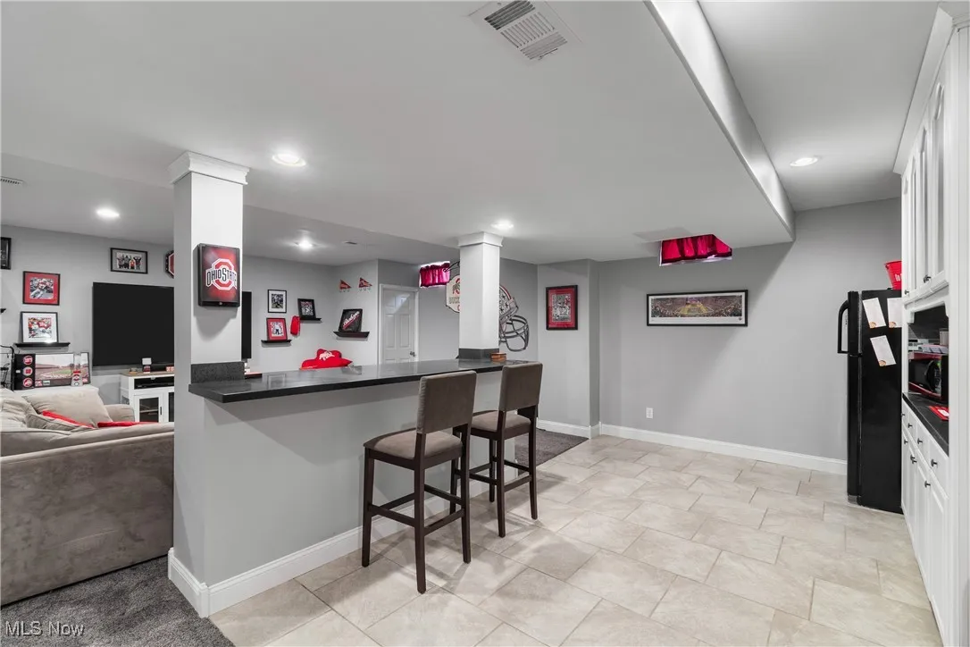 Kitchen with a kitchen breakfast bar, freestanding refrigerator, open floor plan, recessed lighting, and a peninsula