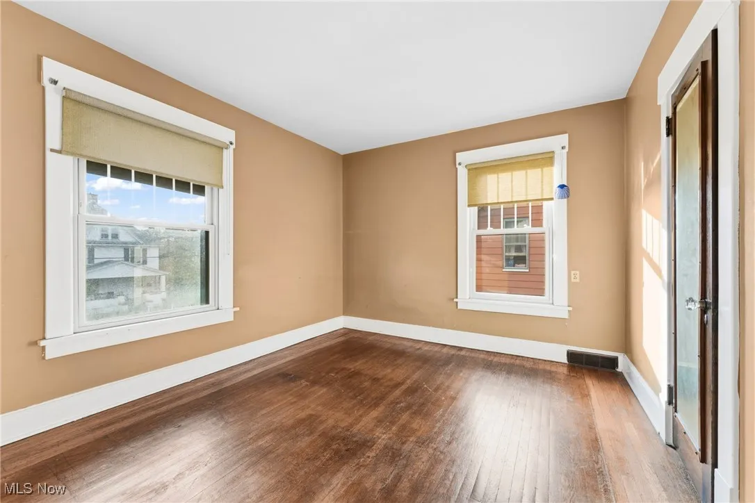 Empty room featuring hardwood / wood-style flooring and healthy amount of natural light