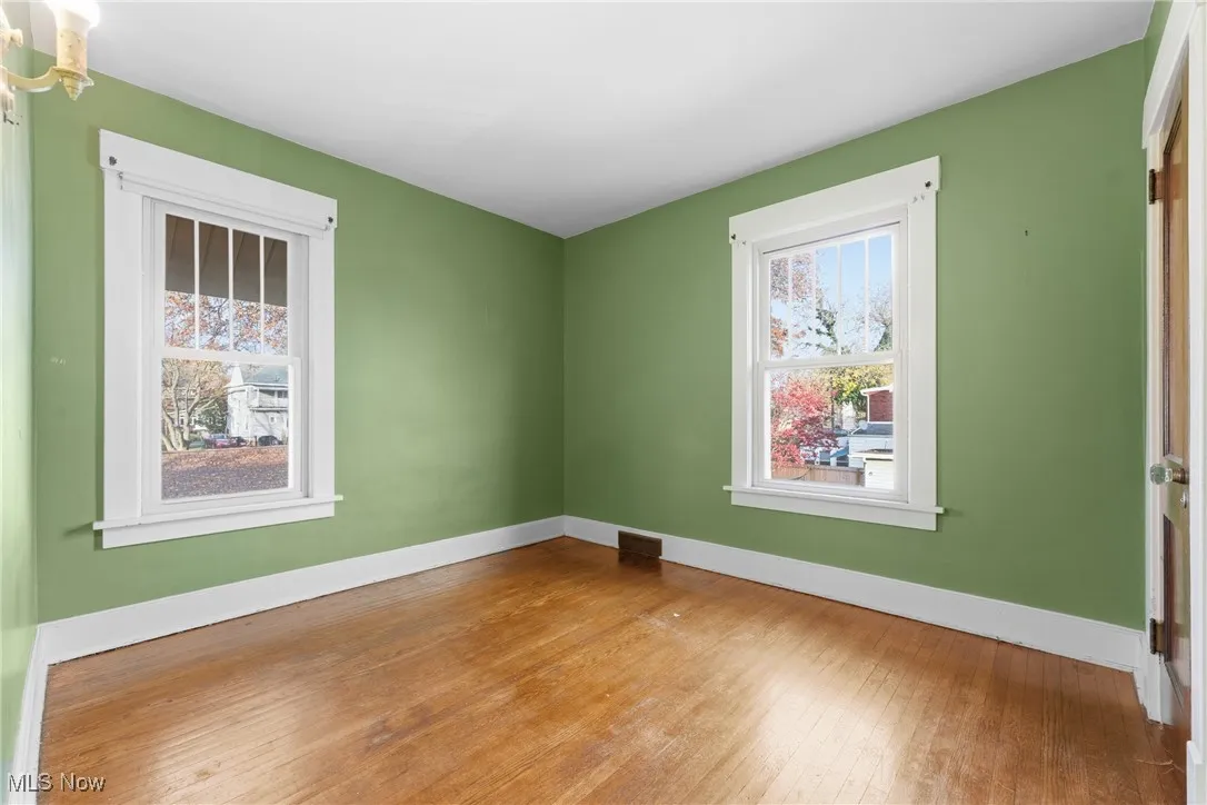 Spare room with hardwood / wood-style floors and baseboards