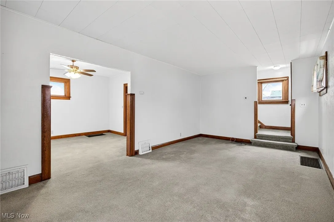 Unfurnished room featuring light carpet and ceiling fan