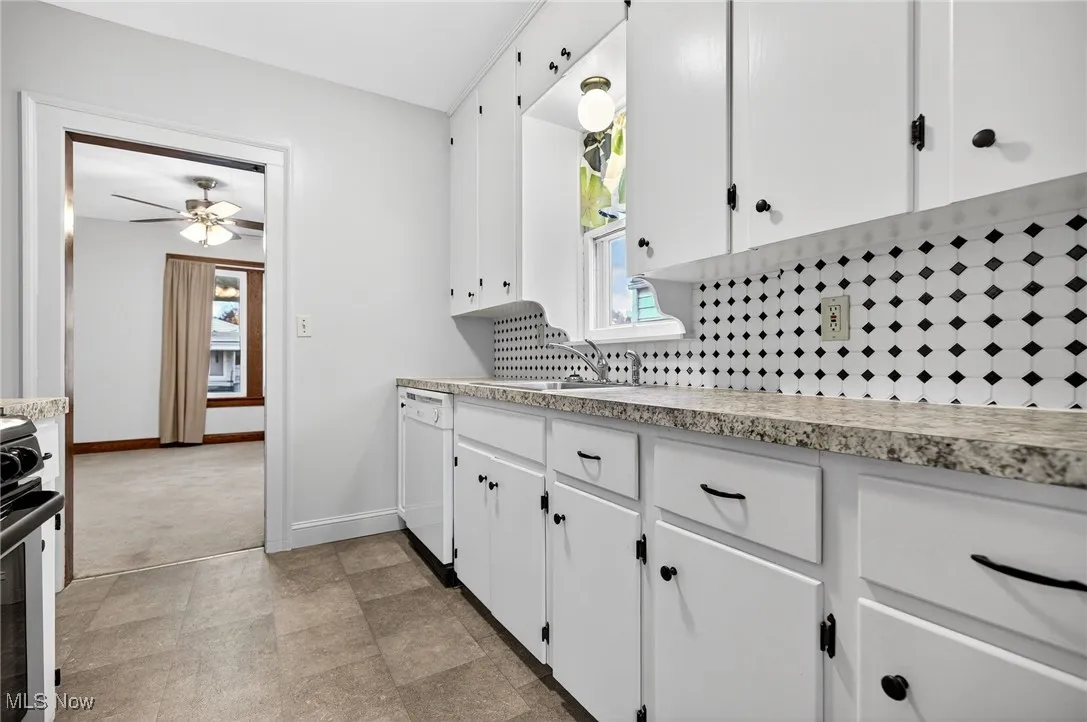 Kitchen with white cabinetry, light countertops, and plenty of natural light