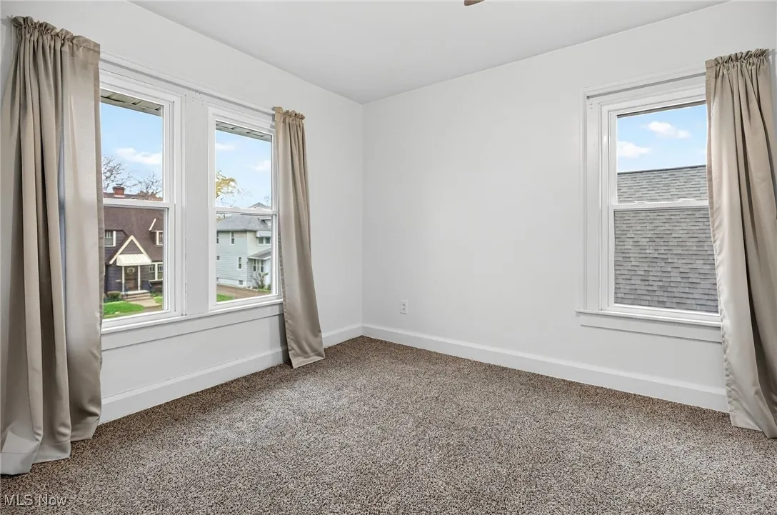 Unfurnished room featuring baseboards and carpet flooring