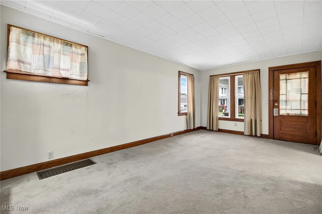 Carpeted empty room featuring baseboards