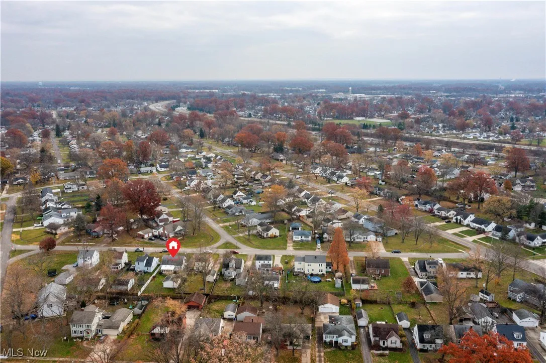 Aerial view of property and surrounding area with nearby suburban area