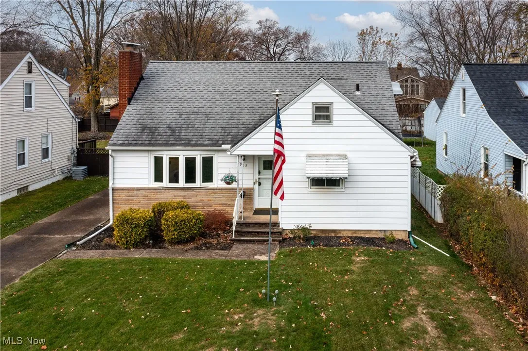 View of front of property featuring roof with shingles, a chimney, and stone siding
