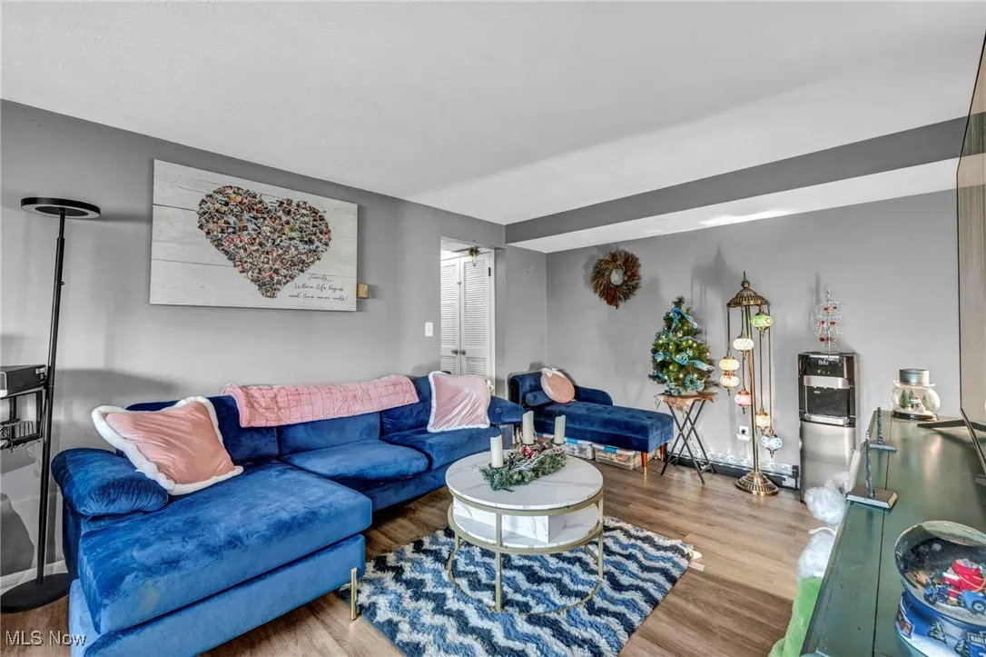 Living area with wood finished floors and a baseboard heating unit
