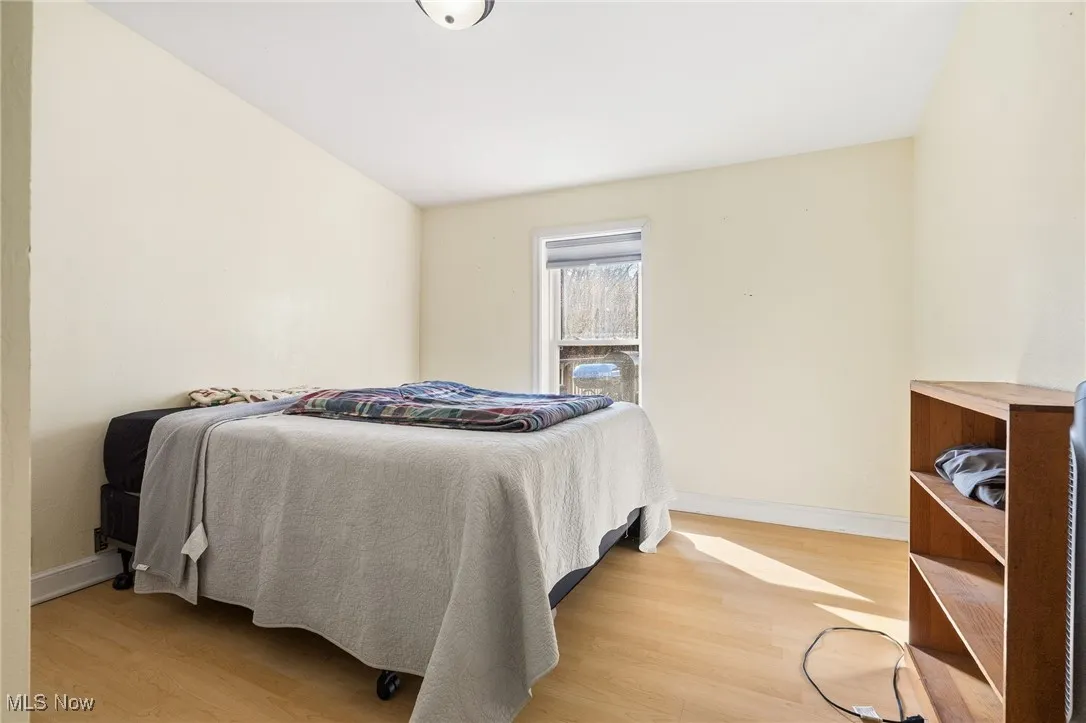 Bedroom with light wood finished floors and baseboards