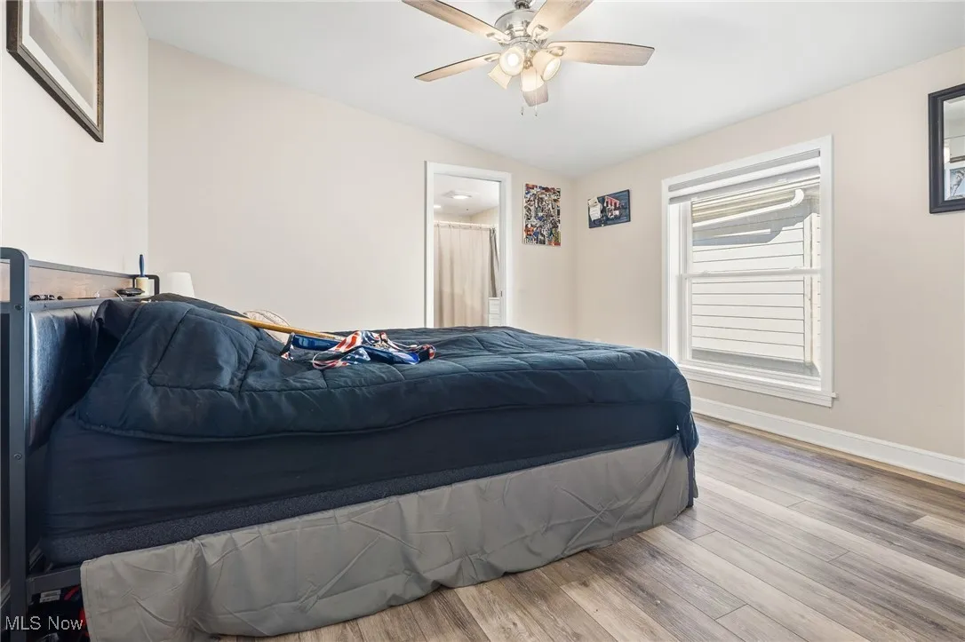 Bedroom featuring lofted ceiling, wood finished floors, and ceiling fan