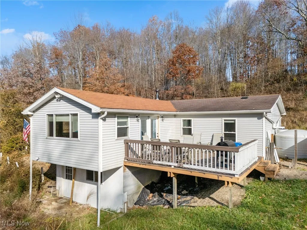 Rear view of house with a wooden deck and a shingled roof