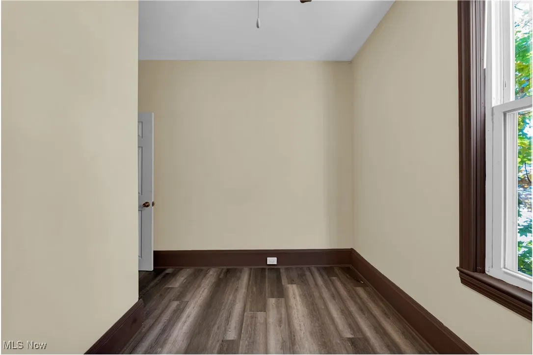 Spare room with dark wood-style flooring and ceiling fan