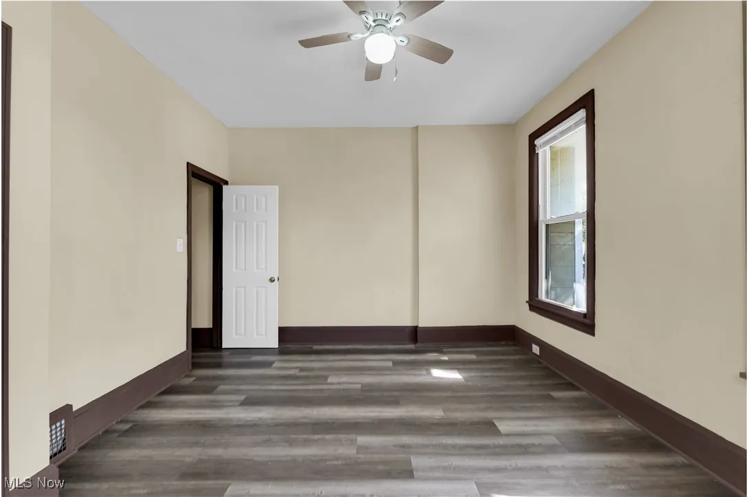 Spare room featuring dark wood-style flooring and ceiling fan
