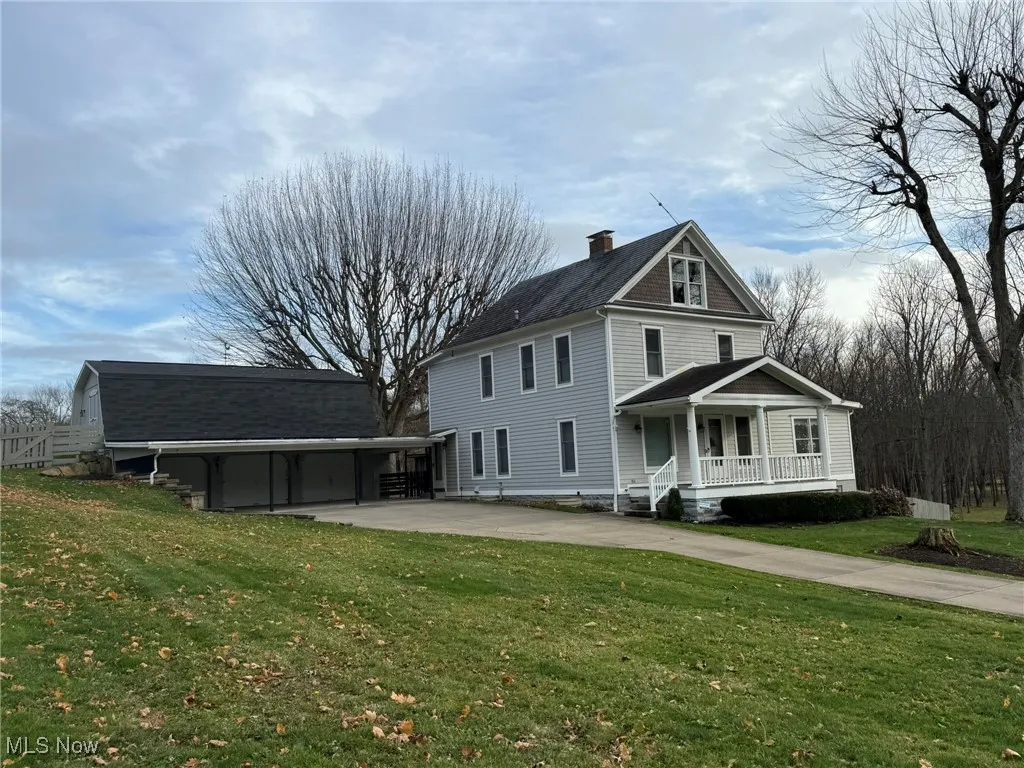 View of front facade featuring driveway, a front yard, a porch, and a chimney