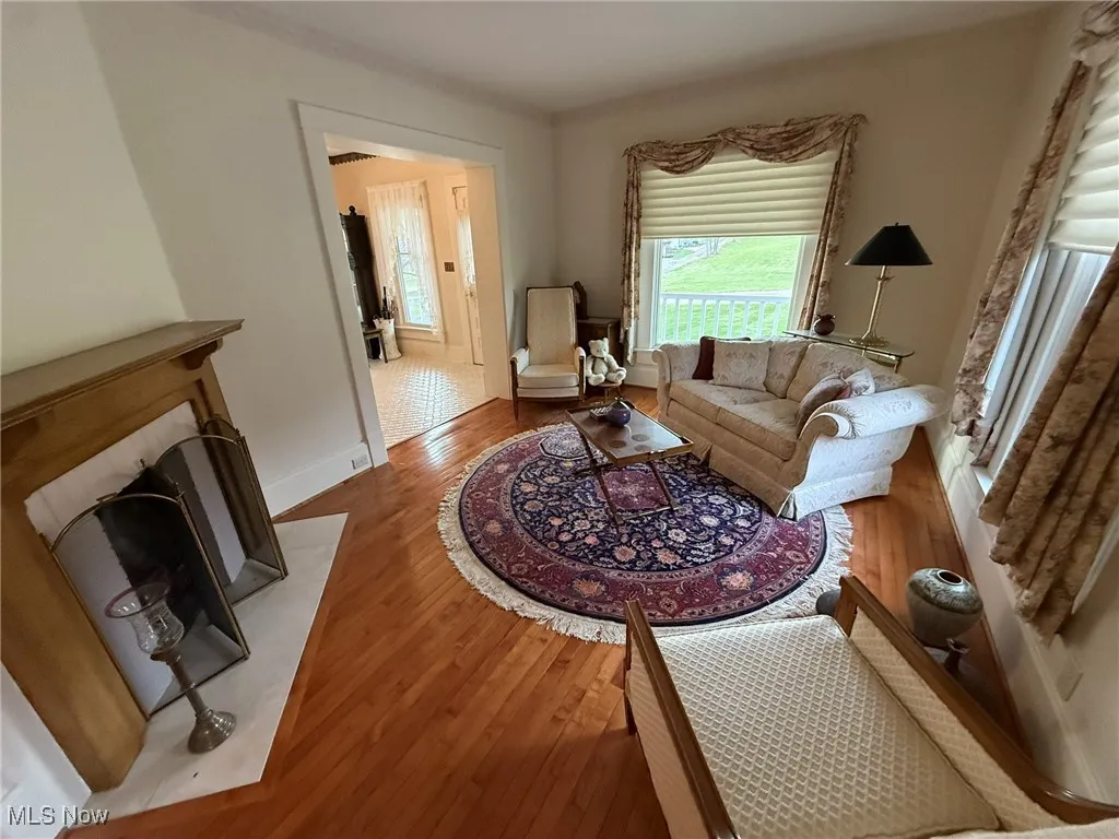 Living room featuring wood finished floors and a fireplace with flush hearth
