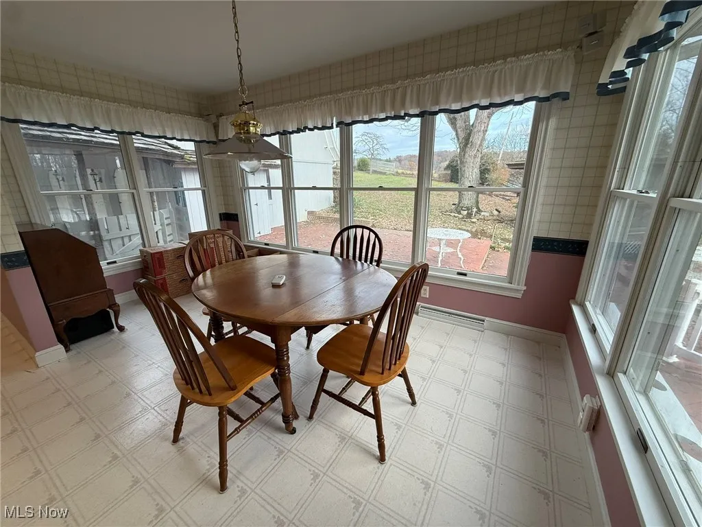 Dining space with light flooring and wallpapered walls